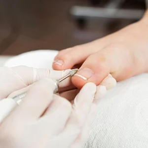 mujer haciendo las uñas de los pies a una clienta
